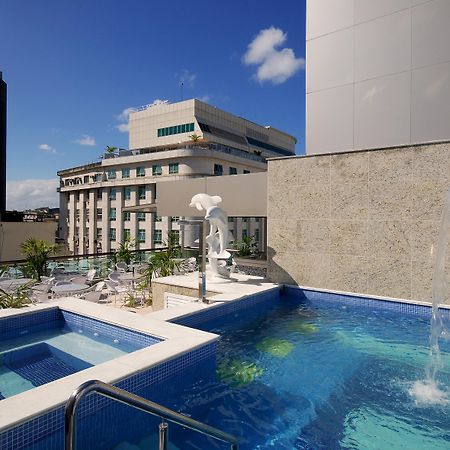 Hotel Atlantico Business Centro Rio de Janeiro Dış mekan fotoğraf The photo shows a rooftop area featuring a swimming pool and a spa. The pool is inviting with a clear blue water, and there appears to be a waterfall feature. Surrounding the pool are areas for relaxation, possibly with sun loungers. In the backgroun